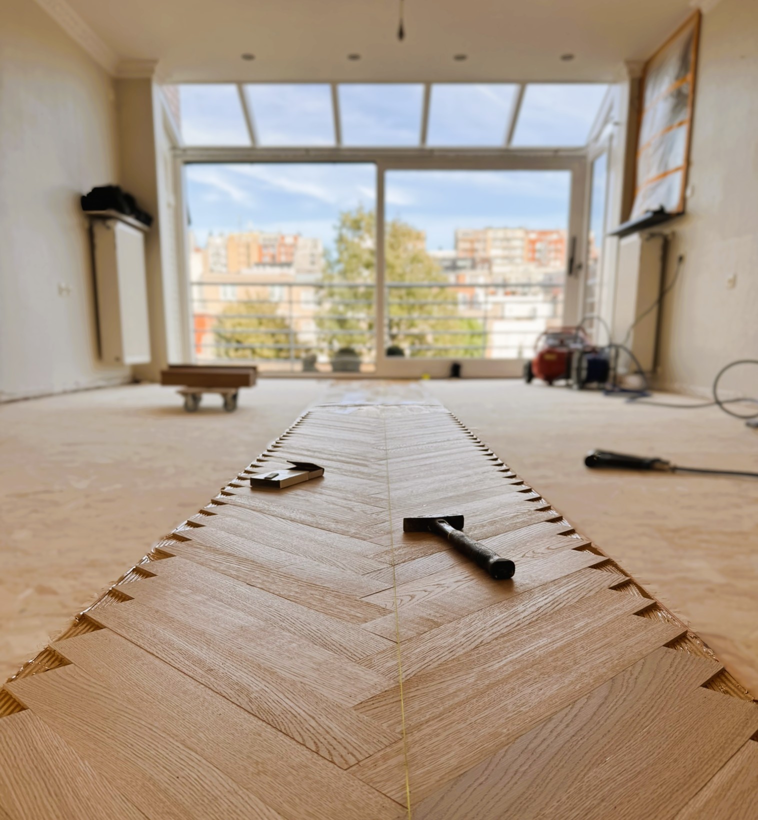 Parketvloer in visgraat van 70 x 490 mm tijdens de plaatsing in een appartement